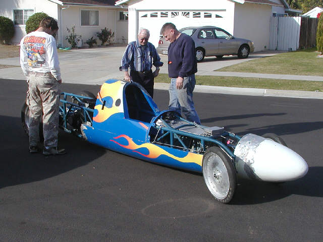 Pushing the car to make sure it rolls straight.